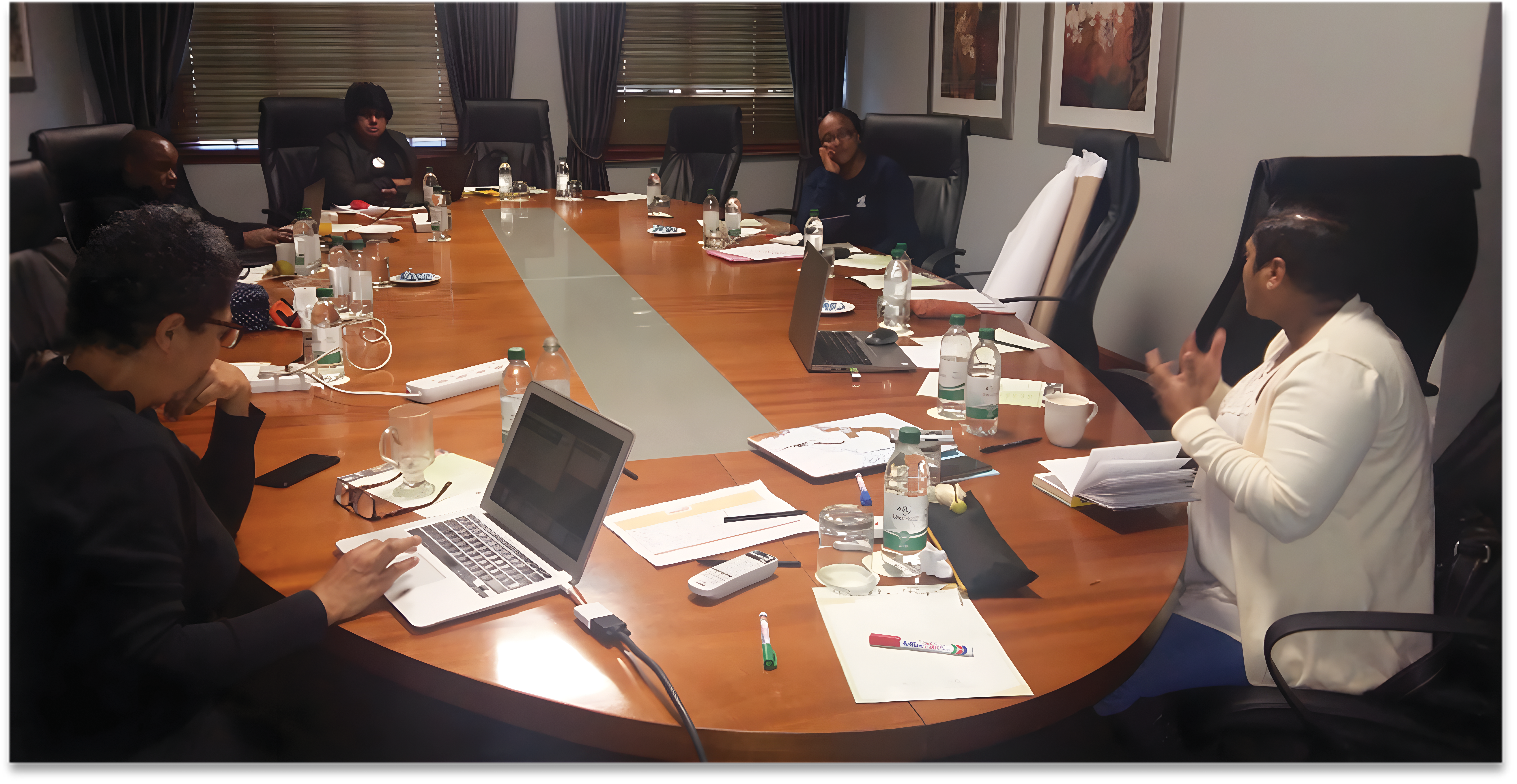 A group of individuals seated around a table engaged in a debrief session on scholarly communication (SC), held in August 2018.